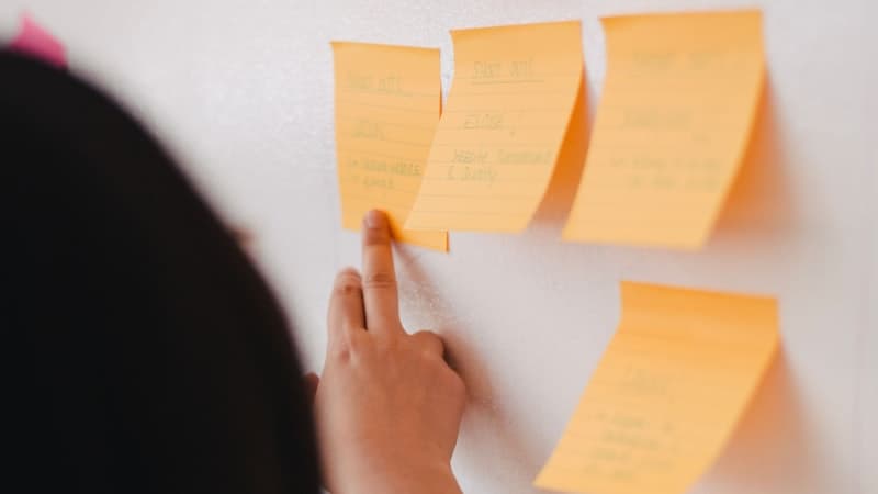 Person organizing sticky notes on a board